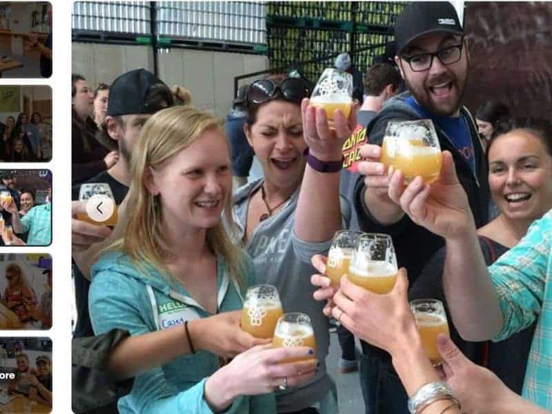 A group of people holding up their beer glasses during a beer tour in Portland, Maine.